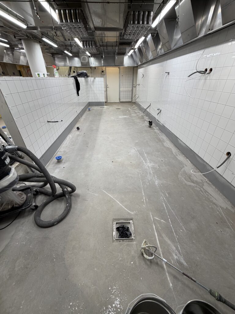 Epoxigolv storkök Stockholm – strukturgolv med 100 mm sockel – före